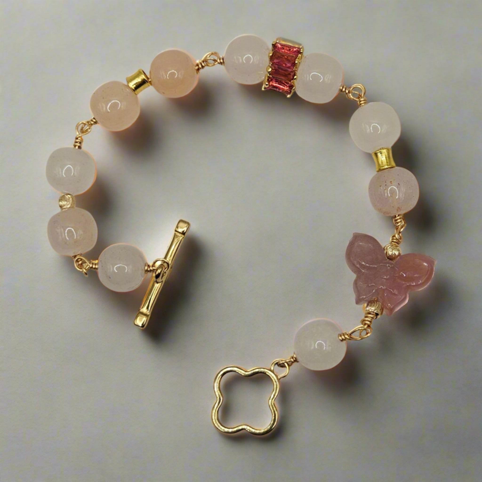 Bracelet with natural stone beads and gold clasp on a light gray background