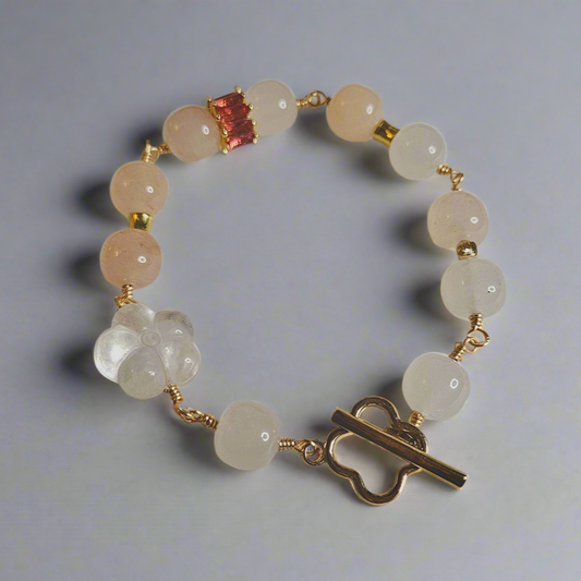 A bracelet with round beads that appear to be clear quartz and golden silk jade, featuring a gold-colored clasp and vacuum plated gold metal.