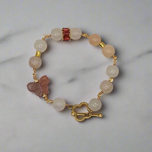 Bracelet with natural stone beads and gold accents on a light gray background